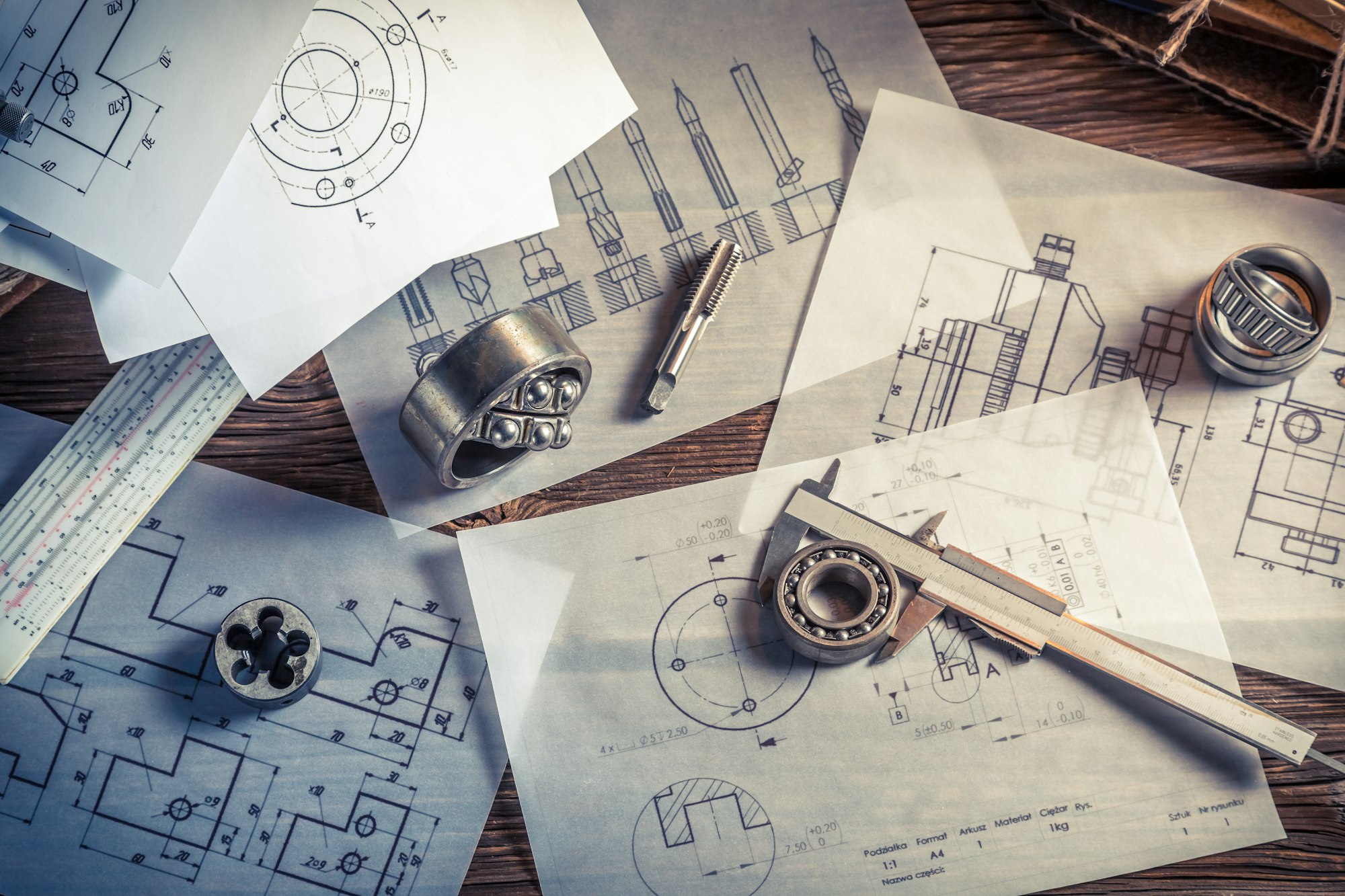 Designing mechanical parts by engineer on old wooden table
